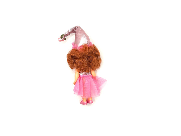 Vintage 1999 Mattel Barbie Kelly Club doll dressed as the Lullaby Munchkin from The Wizard of Oz. The miniature doll features curly red hair, a pink and silver tutu outfit, a tall pointed conical hat, and pink shoes, displayed against a clean white background