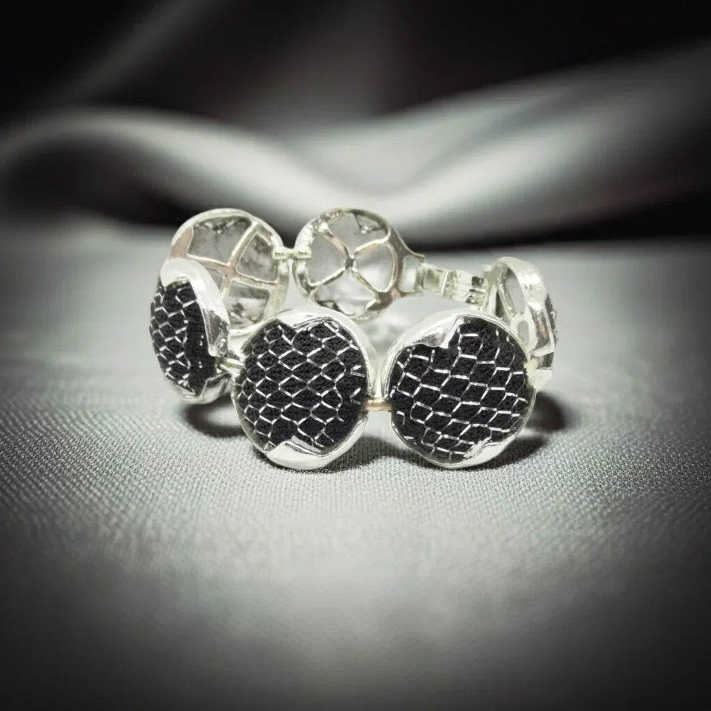Dramatic Vintage Silver Mesh and Black Panels Bracelet,This vintage bracelet exhibits a subtle medieval charm and has been crafted with six circular silver tone frames, each containing a domed disc. The discs are secured within the frames with black netting and finished with a silver mesh.