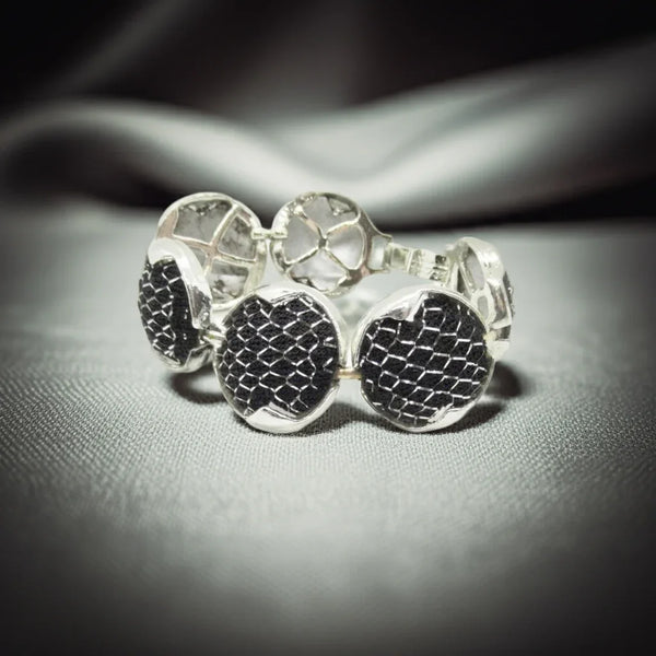 Dramatic Vintage Silver Mesh and Black Panels Bracelet,This vintage bracelet exhibits a subtle medieval charm and has been crafted with six circular silver tone frames, each containing a domed disc. The discs are secured within the frames with black netting and finished with a silver mesh.