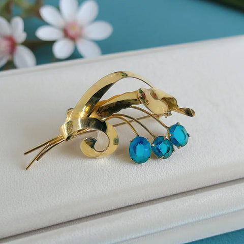 Perfect for vintage lovers: our Striking Gold Filled Oval Teal Blue Vintage Flower Spray Brooch provides timeless charm with bold teal stones. Shop today!