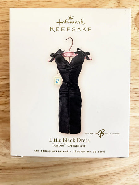 The ornament, featuring the classic and times "little black dress" appears on a pink hanger. Designed by Julie Forsyth, Hallmark Keepsake Artist, the ornament is handcrafted and the dress is actual fabric. it is perfect for both the Barbie aficionado or fashion follower. Made in China. 