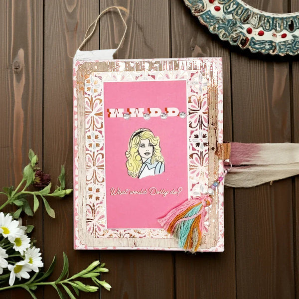 "What Would Dolly Do? This handmade mini&nbsp; album featuring Dolly Parton is a must-have for any fan or person of an optimistic nature,. Made with mixed media, this 6" by 5" album is a unique way to showcase your love for the iconic singer. Perfect for storing tickets, photos, and other memorabilia, it's a fitting homage to the Queen of Country.