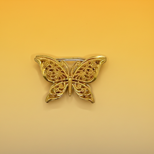 Vintage Miriam Haskell jewelry collection: A signed Russian gold-plated filigree butterfly pin from the 1950s with detailed openwork wings.