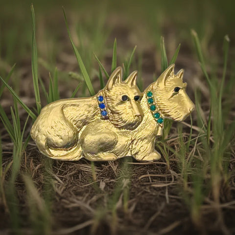 This delightful vintage brooch showcases a pair of furry terrier pals cuddled up. One has a sparkling blue collar, while the other rocks a cool green one. Their eyes are a striking dark blue/black.