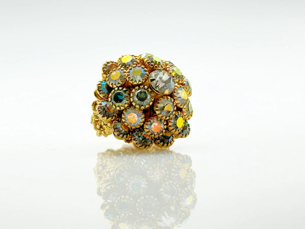 This stunning vintage statement ring captures the glamour of the 1960s and 70s with its commanding domed crown of shimmering Aurora Borealis cabochons. The iridescent glass stones dance with rainbow hues, creating mesmerizing light-play from every angle.