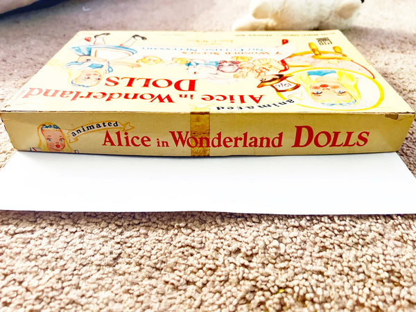 This is a vintage boxed set of "Animated Alice in Wonderland Dolls" paper dolls manufactured by the Milton Bradley Company. The set, number 4109, was designed by Emma C. McKean and includes seven scene cards where the dolls can be inserted into die-cut slits to "animate" the scenes.