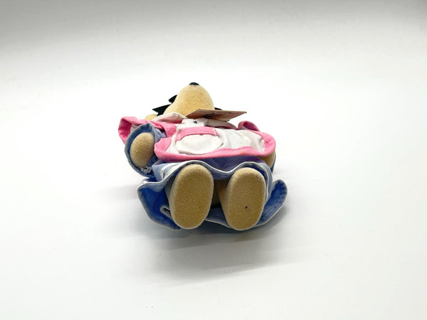 A small plush toy wearing a pink and blue outfit, photographed on a plain white studio background.