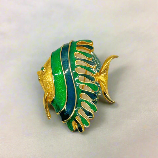 This charming angel fish brooch is a work of art with its vibrant blue and green enamel on a golden backdrop. His vibrant green eye will see all of the compliments you'll receive.