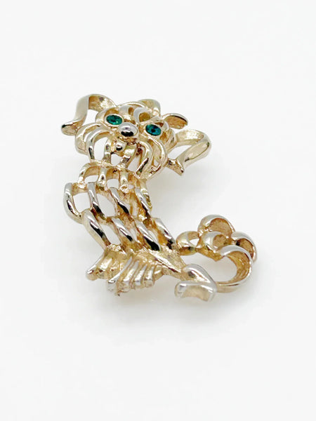 This endearing vintage dog brooch captures a pup with luxuriant ears and brilliant green rhinestone eyes, poised with anticipation. Measuring 1.75" tall, it is engraved with the name Avon in bold, capital letters. Captivating and classic vintage dog brooch with stunning green rhinestone eyes, and a must-have for any dog lover.