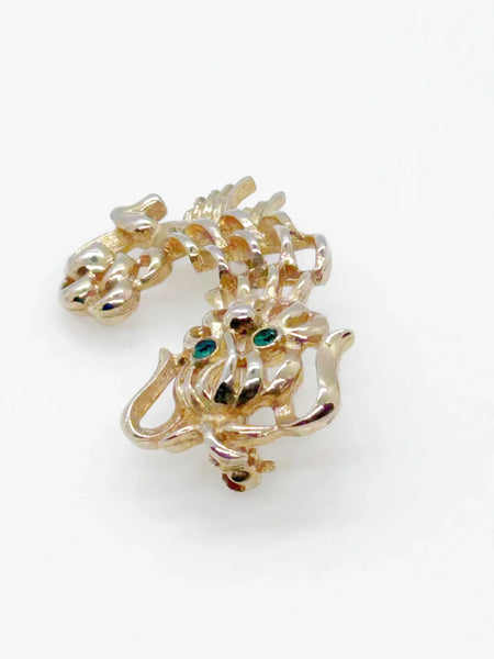 This endearing vintage dog brooch captures a pup with luxuriant ears and brilliant green rhinestone eyes, poised with anticipation. Measuring 1.75" tall, it is engraved with the name Avon in bold, capital letters. Captivating and classic vintage dog brooch with stunning green rhinestone eyes, and a must-have for any dog lover.