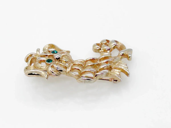 This endearing vintage dog brooch captures a pup with luxuriant ears and brilliant green rhinestone eyes, poised with anticipation. Measuring 1.75" tall, it is engraved with the name Avon in bold, capital letters. Captivating and classic vintage dog brooch with stunning green rhinestone eyes, and a must-have for any dog lover.