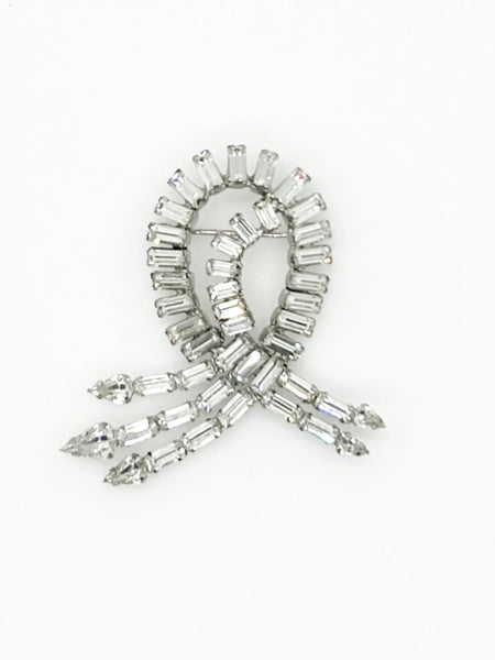 This dazzling Weiss brooch features a stunning arrangement of baguette and pear-shaped rhinestones, all prong set in a layered design that catches the light beautifully. The stones are remarkably clear and radiant, enhancing its vintage charm.