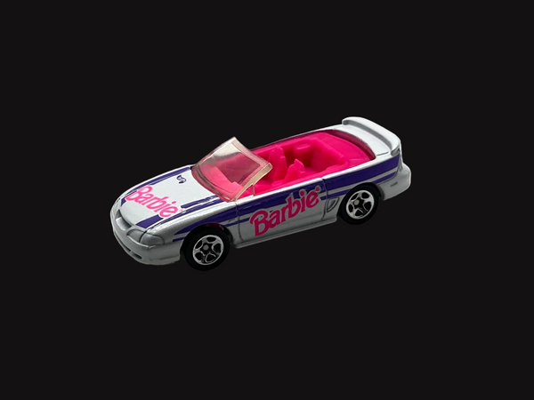 Hot Wheels Barbie 1996 Ford Mustang GT convertible, featuring a silver exterior with purple and pink branding.