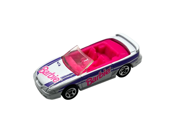 Hot Wheels Barbie 1996 Ford Mustang GT convertible, featuring a silver exterior with purple and pink branding.