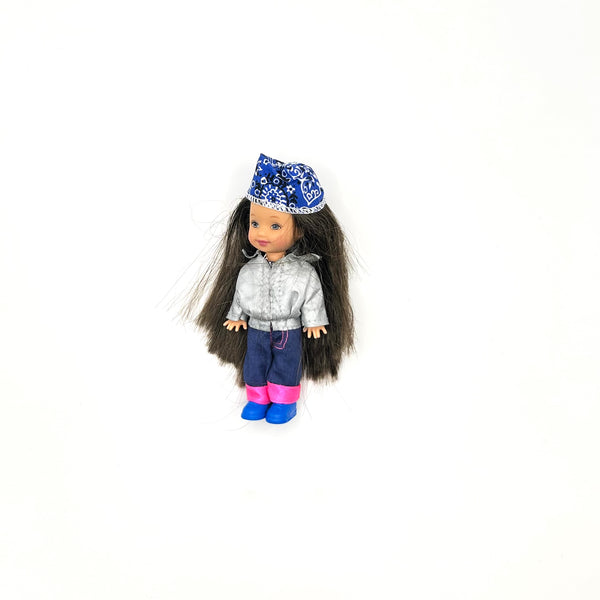 Vintage Mattel Barbie Kelly Club Biker Baby Belinda miniature doll. The 4-inch brunette doll is shown in her original outfit featuring a silver jacket, blue paisley bandana, blue pants, and blue boots