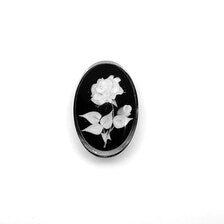 oval cameo brooch depicting a white rose with leaves carved against a dark, polished background. 
