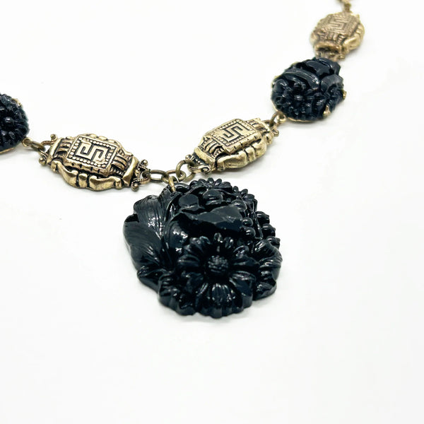 Vintage Art Deco choker necklace featuring gold-tone brass filigree links, two oval black beads, and a large textured black cluster central pendant