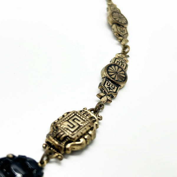 Vintage Art Deco choker necklace featuring gold-tone brass filigree links, two oval black beads, and a large textured black cluster central pendant