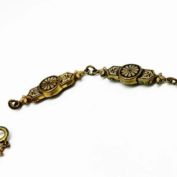 Vintage Art Deco choker necklace featuring gold-tone brass filigree links, two oval black beads, and a large textured black cluster central pendant