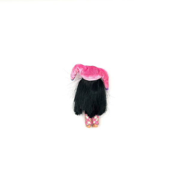 Rear view of a vintage 1999 Mattel Barbie Kelly Club Jester Jenny 4-inch miniature doll with long black hair and a pink jester outfit, isolated on a white background for e-commerce