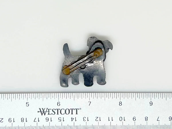 This is an adorable and engaging dog brooch is perfect for adding a playful touch to any outfit. This charming terrier dog brooch features a head that tilts in multiple directions and a red enameled tongue. 