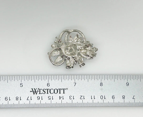 With a touch of elegance, this vintage brooch boasts delicate power blue rhinestones accented by six lustrous faux pearls of different sizes.