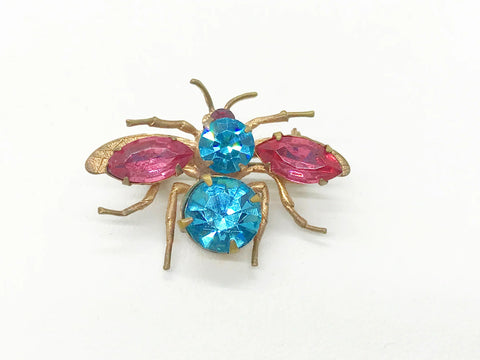 This is probably the prettiest insect you could hope to find—a truly exceptional vintage treasure you won't want to miss. Crafted from lustrous golden metal with meticulous attention to detail, this charming brooch features vibrant round aqua and pink stones that instantly draw the eye. 