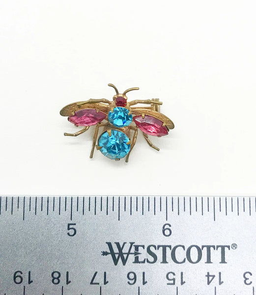 This is probably the prettiest insect you could hope to find—a truly exceptional vintage treasure you won't want to miss. Crafted from lustrous golden metal with meticulous attention to detail, this charming brooch features vibrant round aqua and pink stones that instantly draw the eye. 
