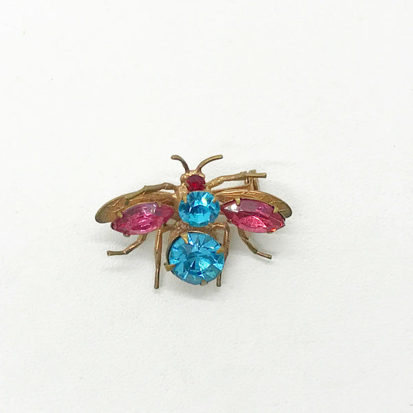 This is probably the prettiest insect you could hope to find—a truly exceptional vintage treasure you won't want to miss. Crafted from lustrous golden metal with meticulous attention to detail, this charming brooch features vibrant round aqua and pink stones that instantly draw the eye. 