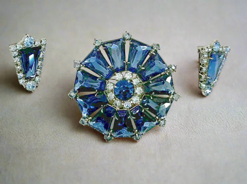 This focal point of this set are the deep blue trapezoid rhinestones set in a round frame. There have accents of lighter blue round stones, with a matching deep blue round stone in the center. The earrings are set with one of the deep blue stones and framed with the paler blue stones.