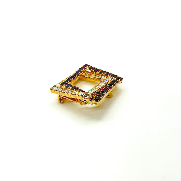Set of two vintage 3D interlocking square brooches. One features purple and clear prong-set rhinestones on a silver-tone frame. The other features opaque orange and sparkling gold AB crystals on a gold-tone geometric frame
