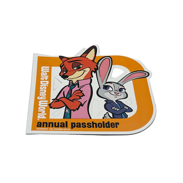 Celebrate your Disney magic with this cheerful 2026 Walt Disney World Annual Passholder Magnet featuring Nick Wilde and Judy Hopps from Zootopia! Shaped like a bold capital 'D', this exclusive winter edition magnet showcases the beloved fox-and-bunny duo in vibrant detail.