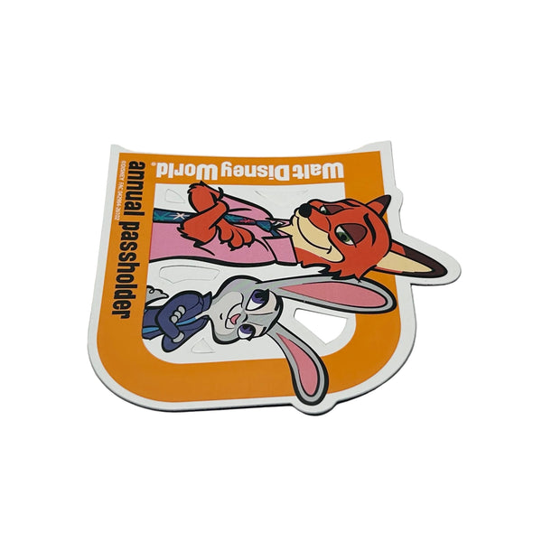 Celebrate your Disney magic with this cheerful 2026 Walt Disney World Annual Passholder Magnet featuring Nick Wilde and Judy Hopps from Zootopia! Shaped like a bold capital 'D', this exclusive winter edition magnet showcases the beloved fox-and-bunny duo in vibrant detail.