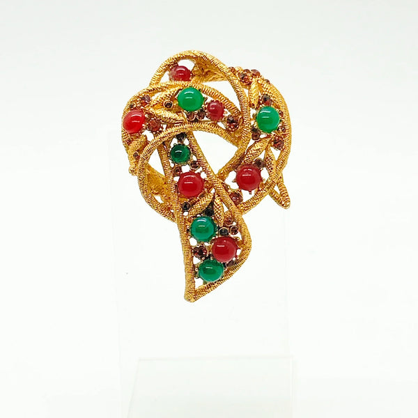 1960s vintage Capri openwork curl brooch featuring textured gold-tone metal set with green faux jade and red carnelian glass cabochons