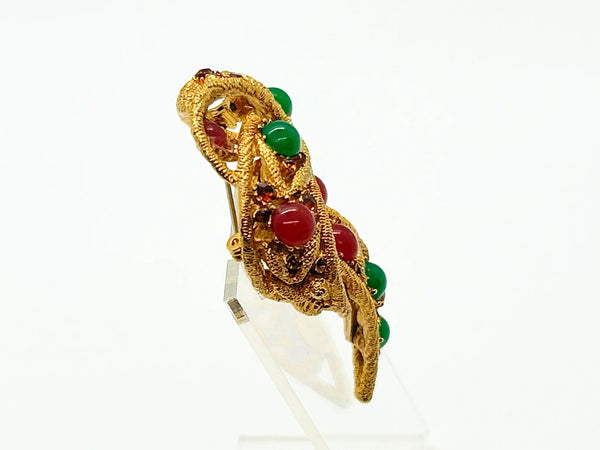 1960s vintage Capri openwork curl brooch featuring textured gold-tone metal set with green faux jade and red carnelian glass cabochons