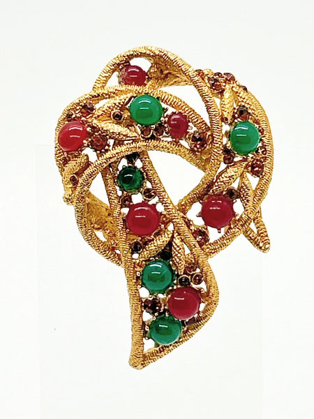 1960s vintage Capri openwork curl brooch featuring textured gold-tone metal set with green faux jade and red carnelian glass cabochons