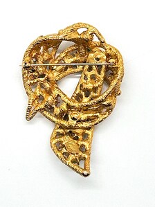 1960s vintage Capri openwork curl brooch featuring textured gold-tone metal set with green faux jade and red carnelian glass cabochons