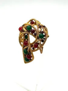 1960s vintage Capri openwork curl brooch featuring textured gold-tone metal set with green faux jade and red carnelian glass cabochons