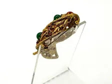 1960s vintage Capri openwork curl brooch featuring textured gold-tone metal set with green faux jade and red carnelian glass cabochons