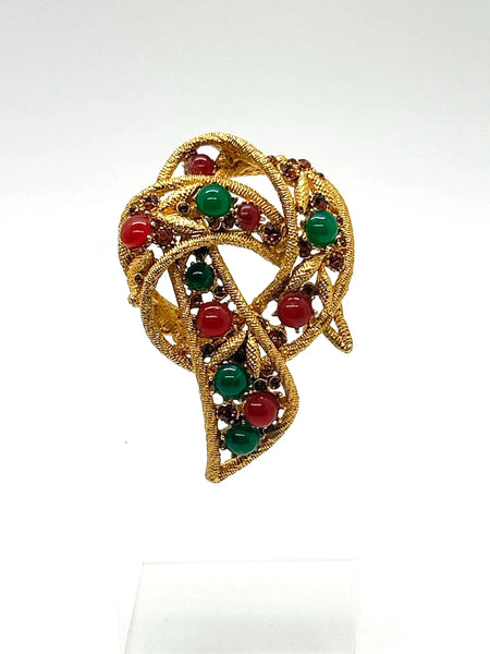 1960s vintage Capri openwork curl brooch featuring textured gold-tone metal set with green faux jade and red carnelian glass cabochons