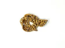 1960s vintage Capri openwork curl brooch featuring textured gold-tone metal set with green faux jade and red carnelian glass cabochons