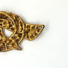 1960s vintage Capri openwork curl brooch featuring textured gold-tone metal set with green faux jade and red carnelian glass cabochons