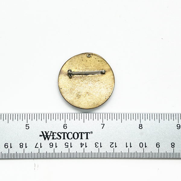 Intriguing modernist brooch with layered circular components, including a dark, possibly rubber or ebonized material, and a verdigris-patinated or painted metal plate.