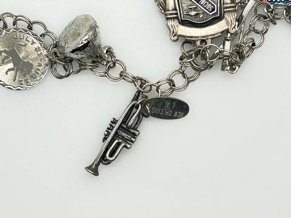 Silver charm bracelet with various charms on a white background
