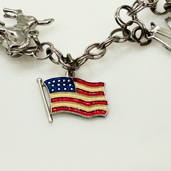 Silver charm bracelet with various charms on a white background