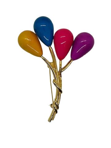 Colorful balloon brooch with gold stem on a white background