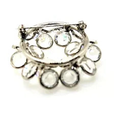 The reverse side of a vintage silver-tone rhinestone brooch displaying the functioning safety pin clasp, and open-back stone settings.