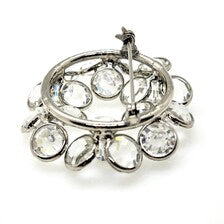 The reverse side of a vintage silver-tone rhinestone brooch displaying the functioning safety pin clasp, and open-back stone settings.