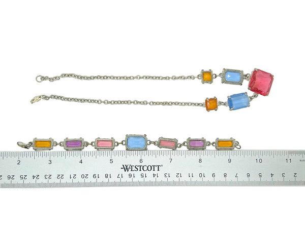 A vintage silver-tone bracelet with rectangular multicolor gemstones, shown alongside a Westcott ruler to indicate its 11-inch length. The bracelet features alternating orange, light blue, pink, and purple stones.