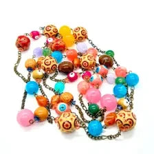 A colorful beaded necklace with a bronze chain, featuring round beads in orange, pink, blue, yellow, and brown, including patterned orange and yellow beads, on a white background.